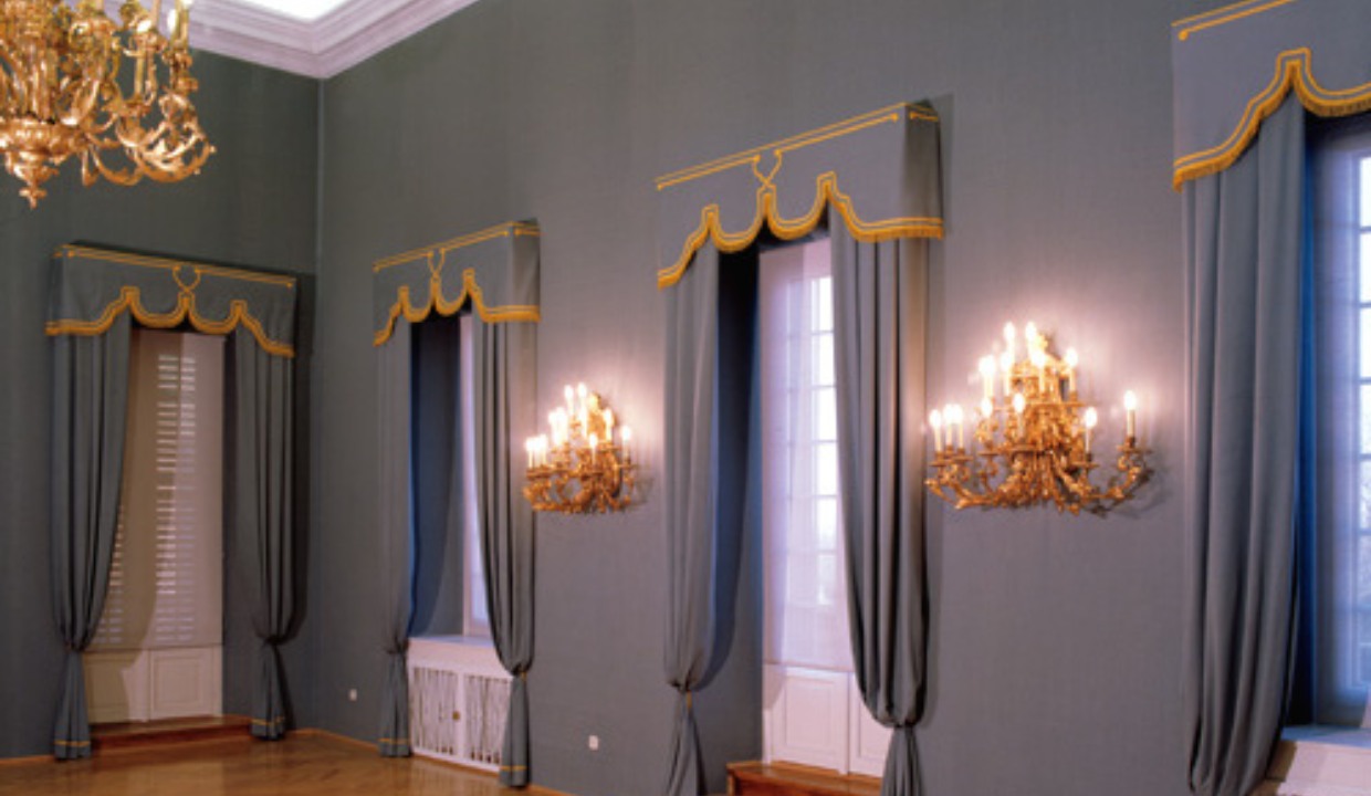 Gray ballroom with many windows and tall walkways with valances at their tops