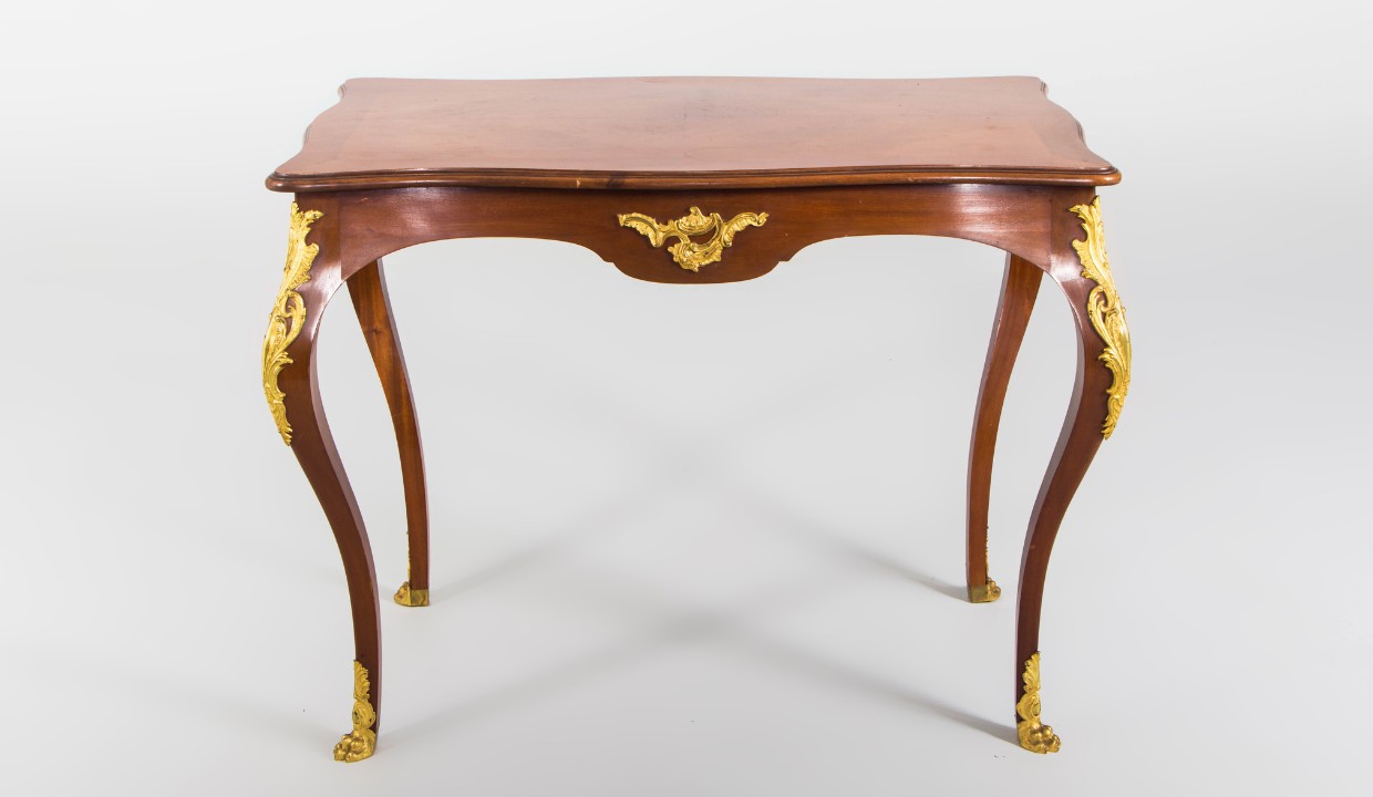 Antique wooden table with gold fixtures that was expertly restored