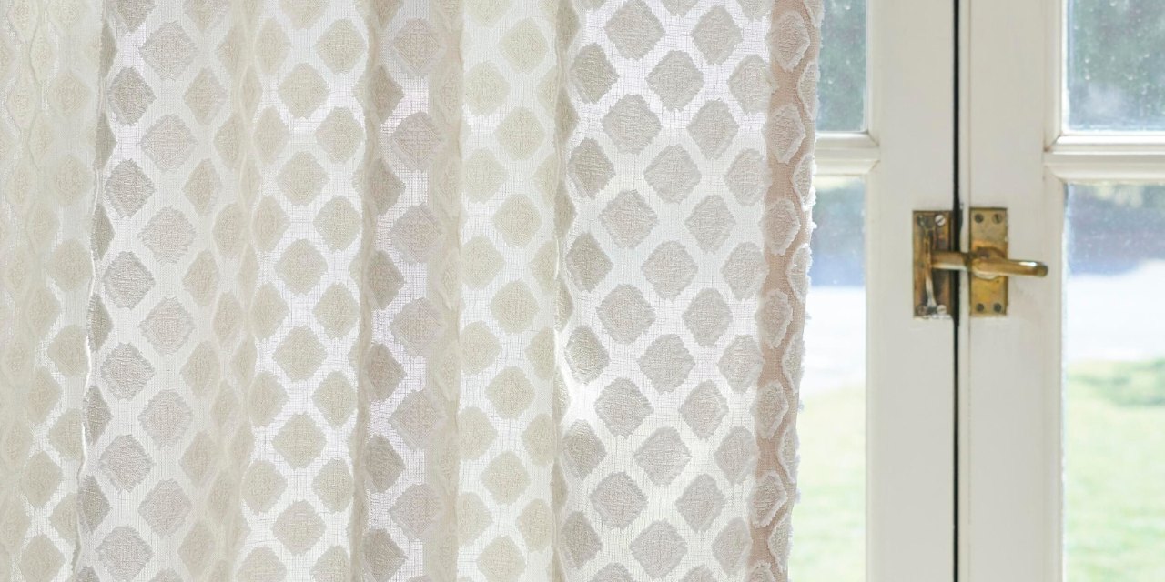 Curtain with textured pattern in front of door to backyard